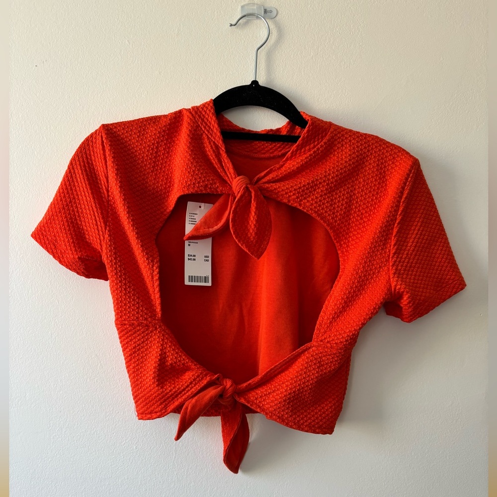 Open back, orange stretch top. Short sleeve. NWT.